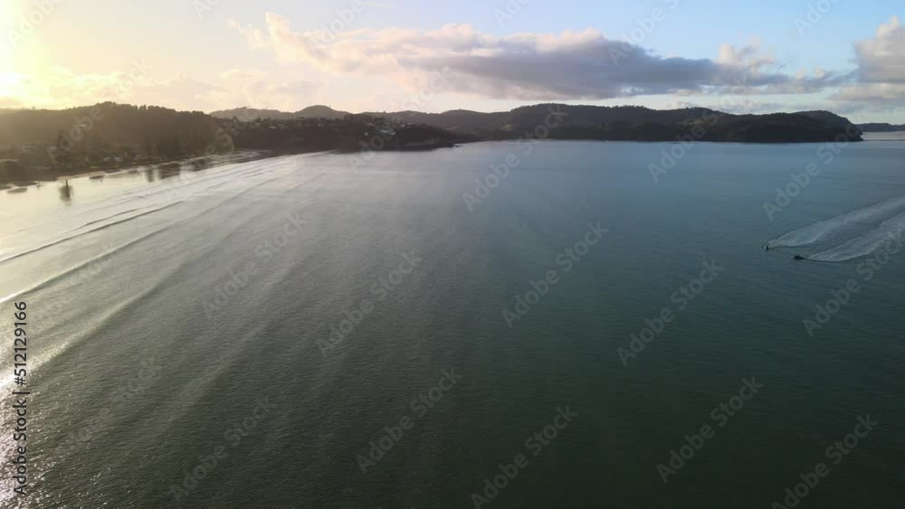 Sunset along New Zealand coastline with calming waves rolling in Sunset along New Zealand coastline with calming waves rolling in