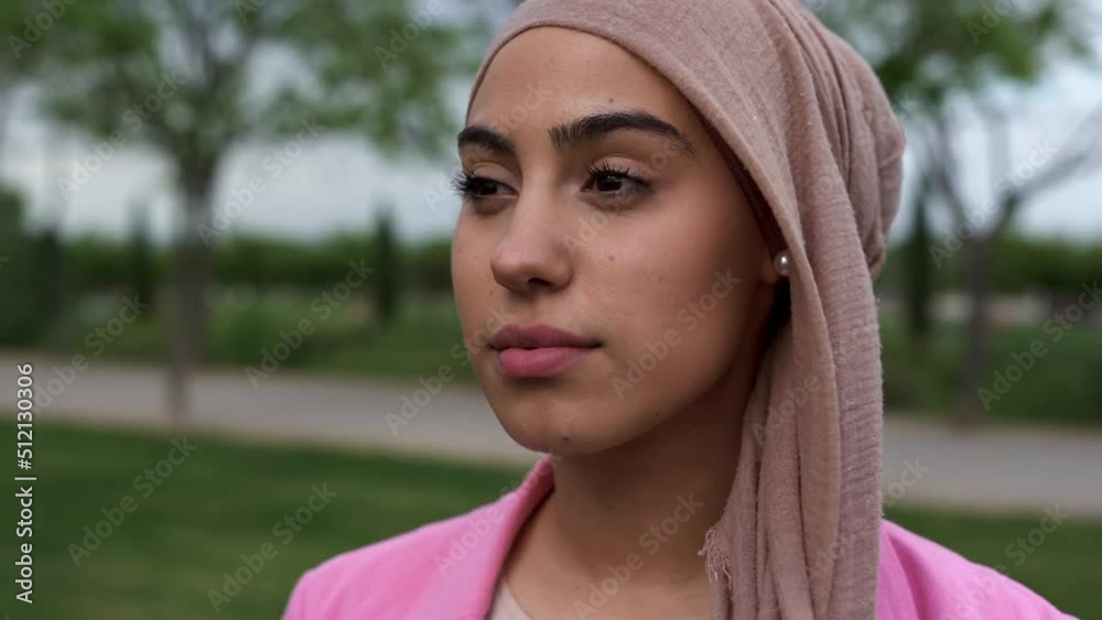 Young beautiful woman wearing head scarf and smiling on camera at city park Young beautiful woman wearing head scarf and smiling on camera at city park