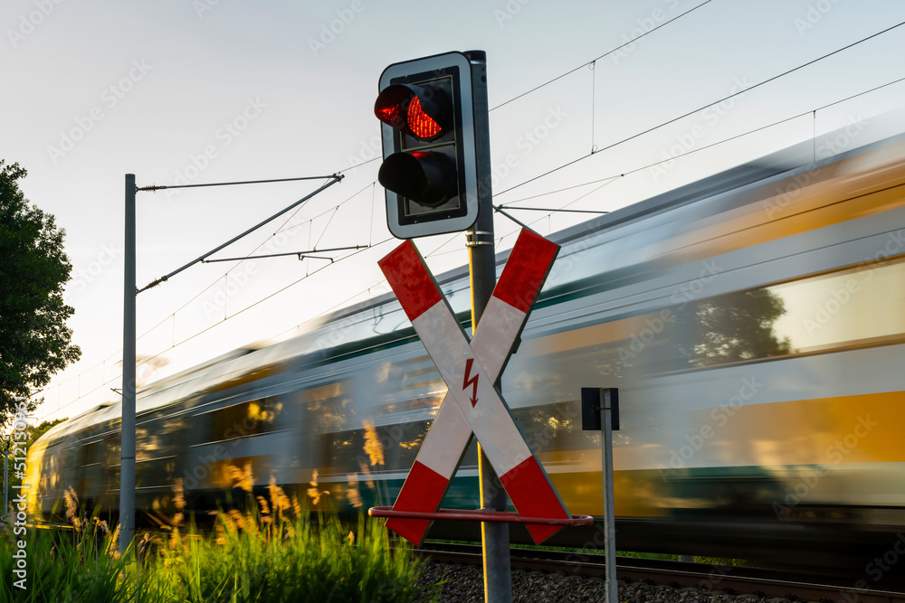 Ein Personenzug fährt am Bahnübergang vorbei
