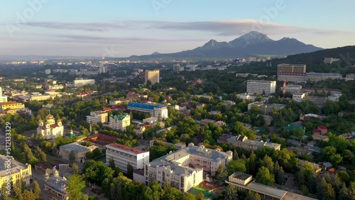 Backwards reveal aerial shot of central part of Pyatigorsk town and Beshtau mount at sunrise. Stavropol Krai, Russia. photo