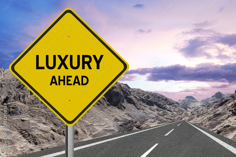 Yellow highway sign with the word Luxury and a metaphoric road leading to future success.