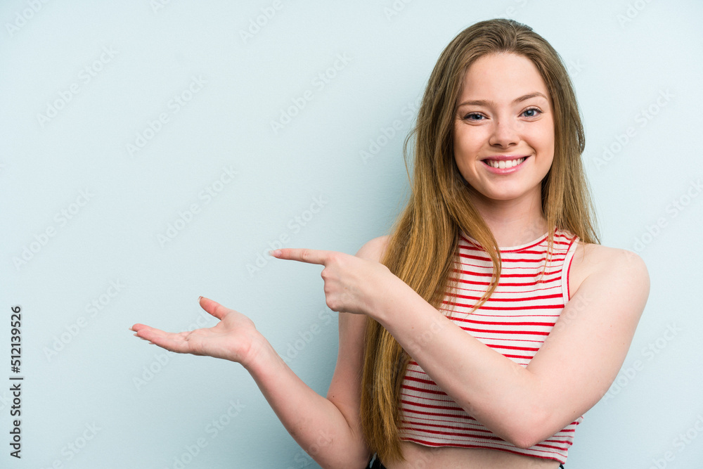 Young caucasian woman isolated on blue background excited holding a copy space on palm.