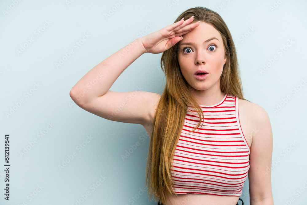 Young caucasian woman isolated on blue background shouts loud, keeps eyes opened and hands tense. Young caucasian woman isolated on blue background shouts loud, keeps eyes opened and hands tense.