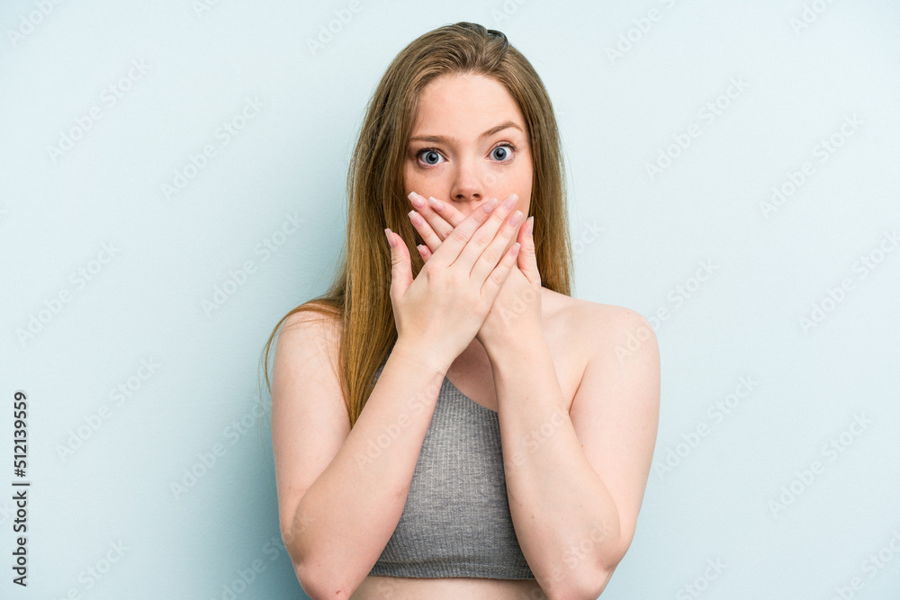 Young caucasian woman isolated on blue background shocked covering mouth with hands. Young caucasian woman isolated on blue background shocked covering mouth with hands.