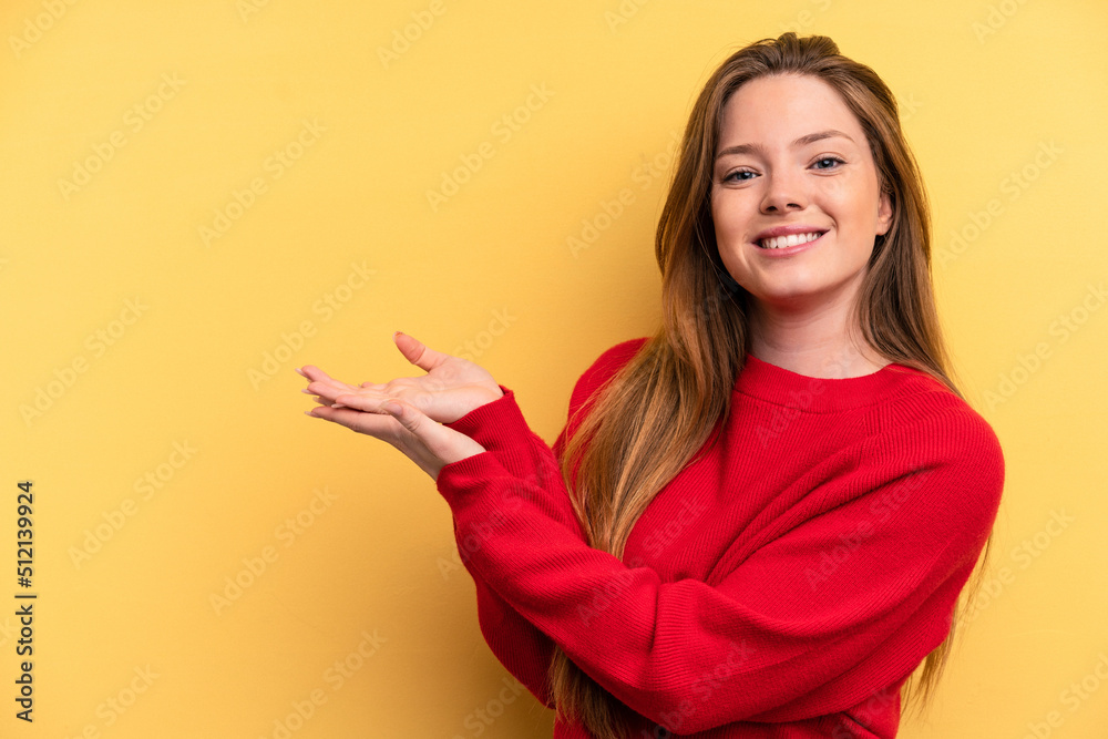 Young caucasian woman isolated on yellow background holding a copy space on a palm. Young caucasian woman isolated on yellow background holding a copy space on a palm.