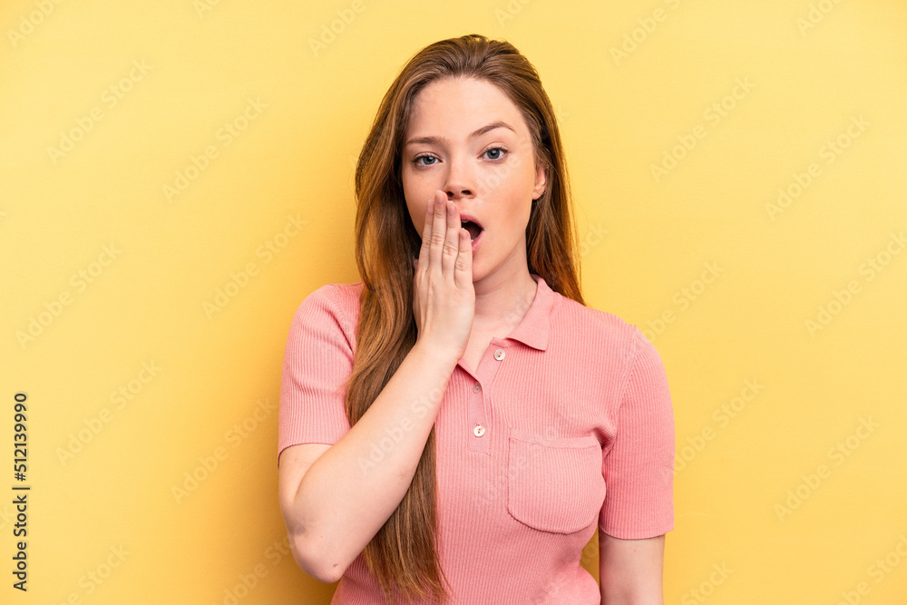 Young caucasian woman isolated on yellow background yawning showing a tired gesture covering mouth with hand. Young caucasian woman isolated on yellow background yawning showing a tired gesture covering mouth with hand.