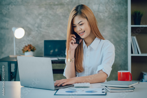 Portrait of smiling pretty young business woman sitting on workplace