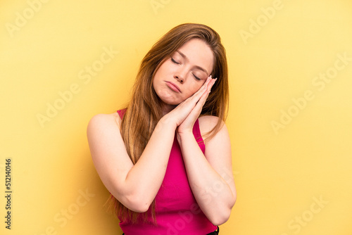 Young caucasian woman isolated on yellow background yawning showing a tired gesture covering mouth with hand.