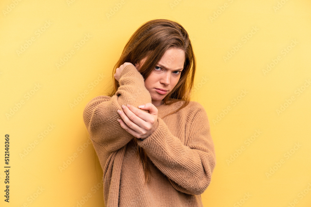 Young caucasian woman isolated on yellow background having a neck pain due to stress, massaging and touching it with hand. Young caucasian woman isolated on yellow background having a neck pain due to stress, massaging and touching it with hand.