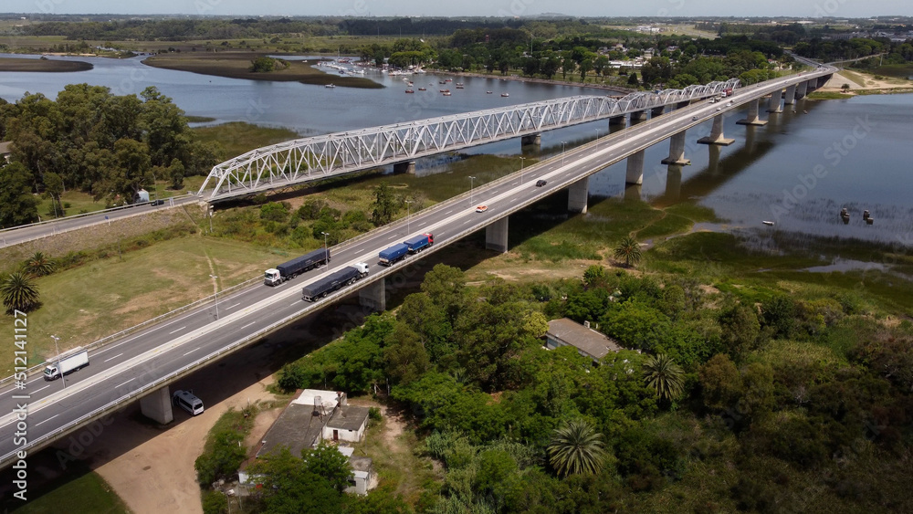 Trucks and cars driving on Barra de Santa Lucia Bridge in Uruguay. Aerial drone view