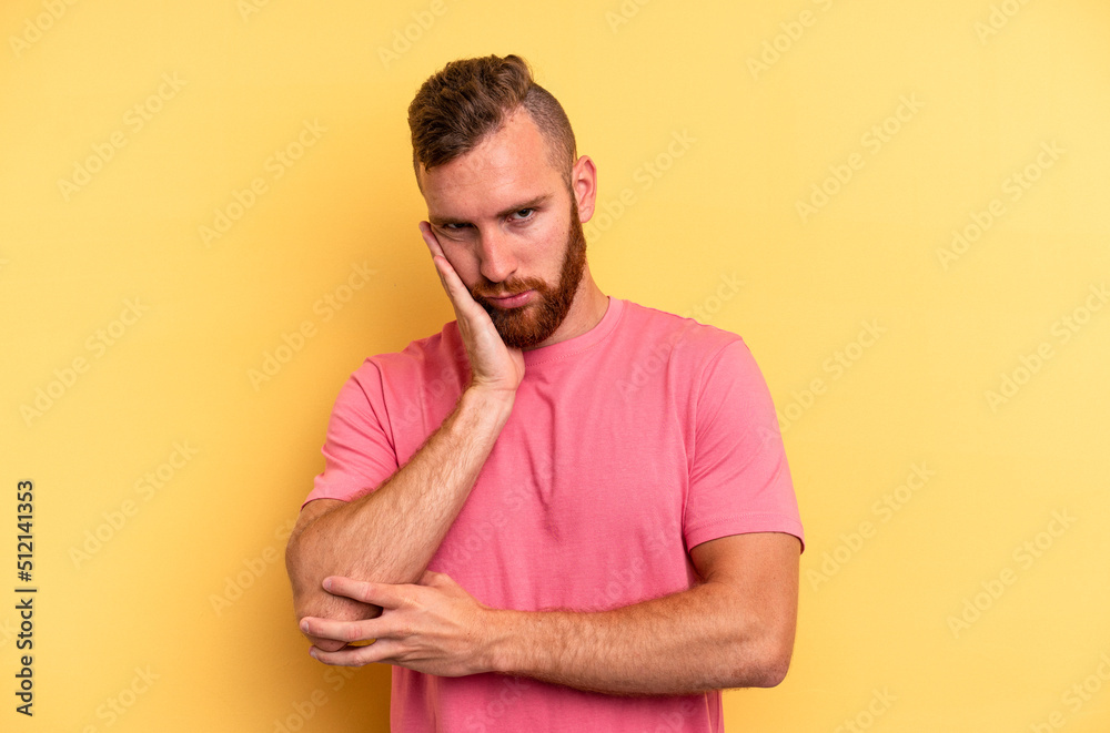 Young caucasian man isolated on yellow background who is bored, fatigued and need a relax day.