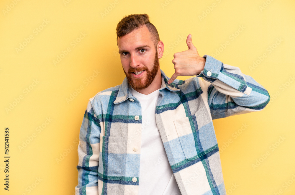 Young caucasian man isolated on yellow background showing a mobile phone call gesture with fingers. Young caucasian man isolated on yellow background showing a mobile phone call gesture with fingers.