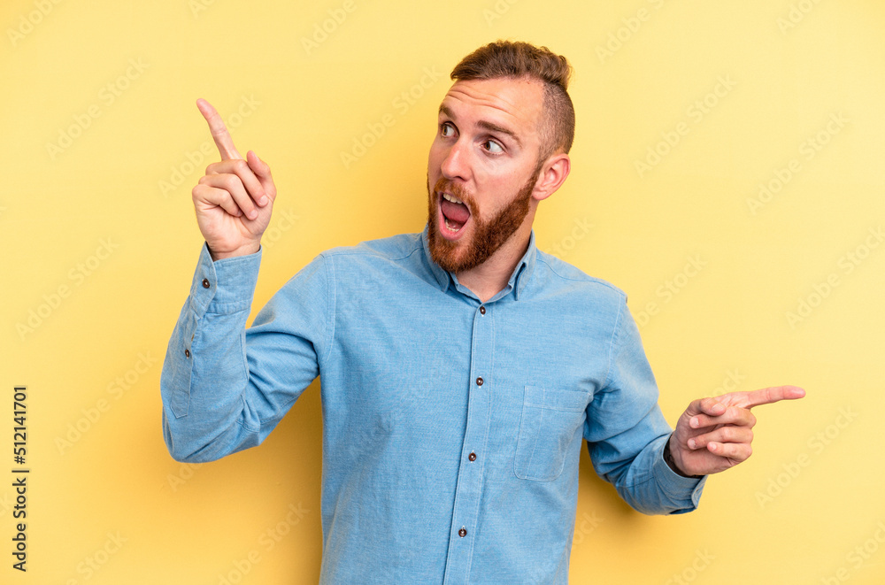 Young caucasian man isolated on yellow background pointing to different copy spaces, choosing one of them, showing with finger. Young caucasian man isolated on yellow background pointing to different copy spaces, choosing one of them, showing with finger.