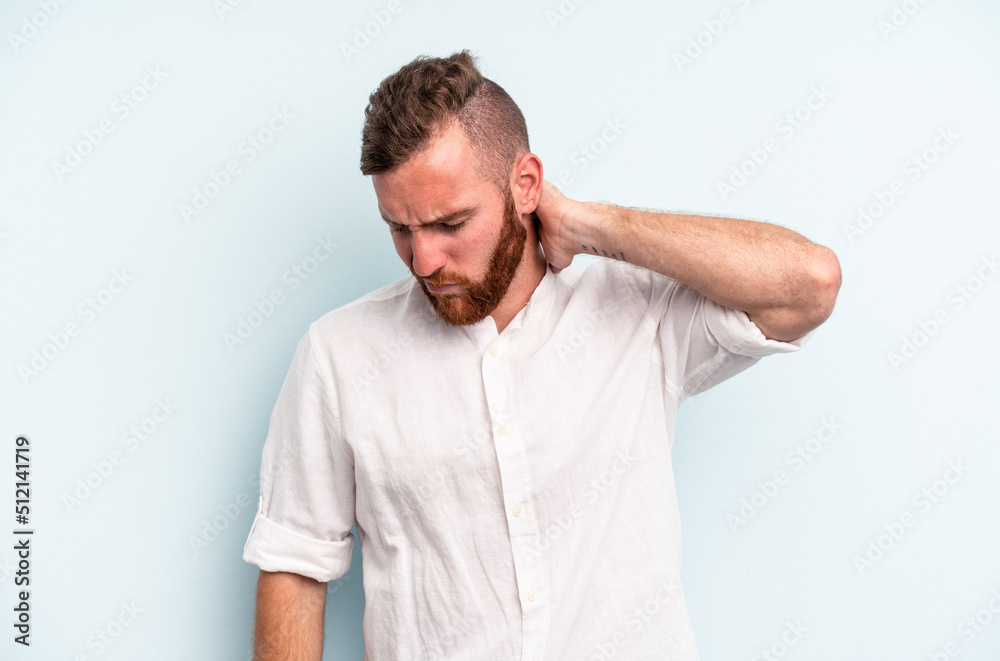 Young caucasian man isolated on blue background suffering neck pain due to sedentary lifestyle. Young caucasian man isolated on blue background suffering neck pain due to sedentary lifestyle.