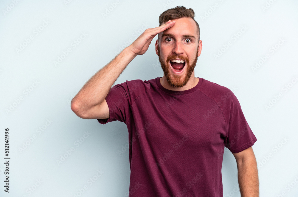 Young caucasian man isolated on blue background shouts loud, keeps eyes opened and hands tense. Young caucasian man isolated on blue background shouts loud, keeps eyes opened and hands tense.