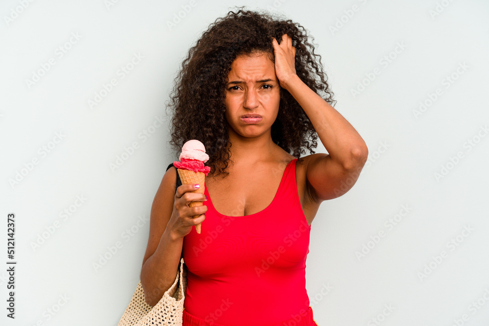 Young brazilian woman going to the beach holding an ice cream isolated on blue background being shocked, she has remembered important meeting. Young brazilian woman going to the beach holding an ice cream isolated on blue background being shocked, she has remembered important meeting.