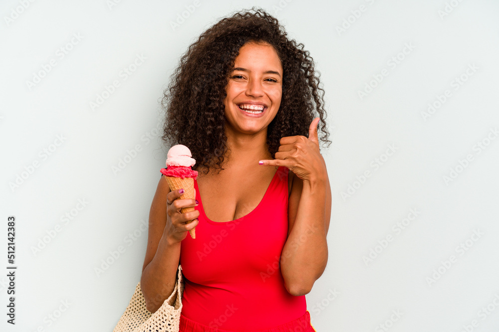 Young brazilian woman going to the beach holding an ice cream isolated on blue background showing a mobile phone call gesture with fingers. Young brazilian woman going to the beach holding an ice cream isolated on blue background showing a mobile phone call gesture with fingers.