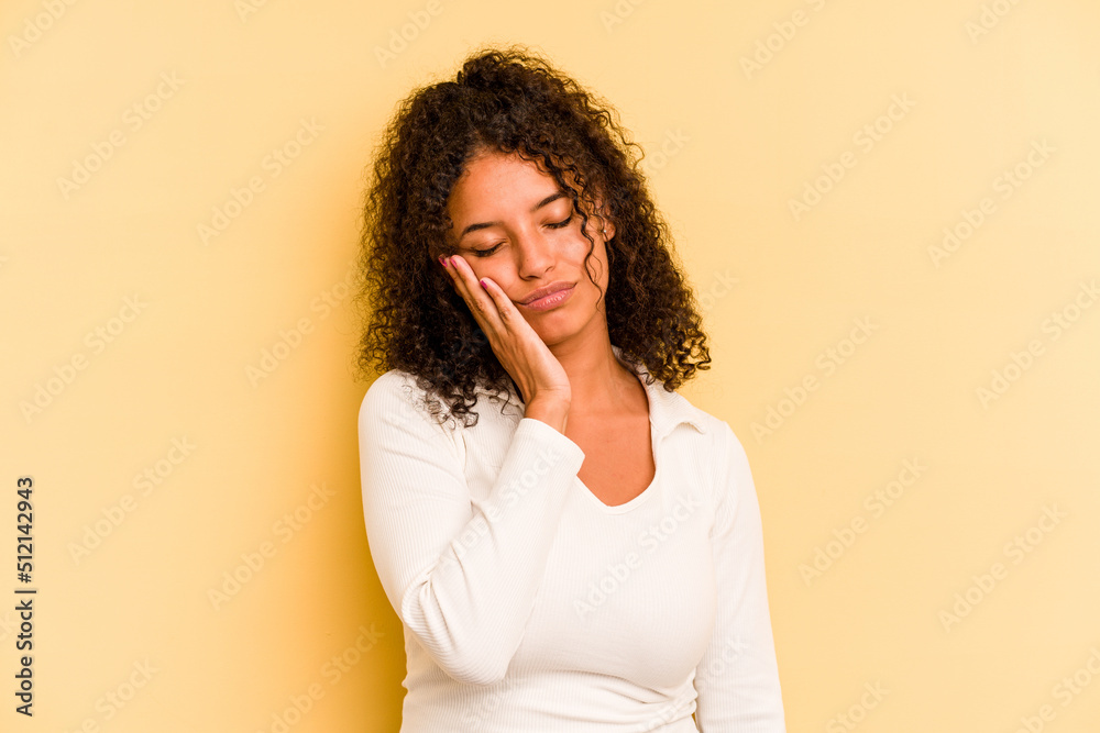 Young Brazilian woman isolated on yellow background who is bored, fatigued and need a relax day. Young Brazilian woman isolated on yellow background who is bored, fatigued and need a relax day.