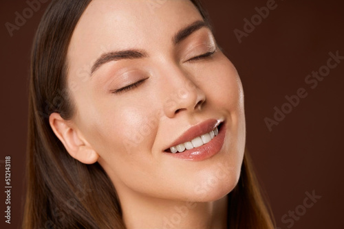 Smiling woman with natural makeup and eyes closed