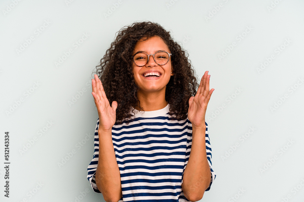 Young Brazilian woman isolated on blue background laughs out loudly keeping hand on chest. Young Brazilian woman isolated on blue background laughs out loudly keeping hand on chest.