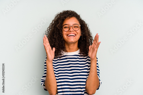 Young Brazilian woman isolated on blue background laughs out loudly keeping hand on chest.