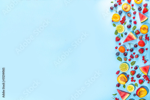 Summer vitamin food concept, various fruit and berries watermelon peach mint plum apricots blueberry strawberry currant, creative flat lay on light blue background top view copy space