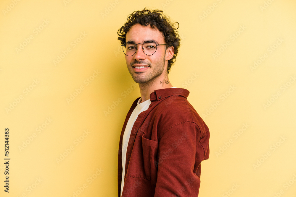 Young caucasian man isolated on yellow background confident keeping hands on hips. Young caucasian man isolated on yellow background confident keeping hands on hips.