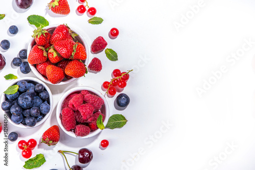 Summer vitamin food concept, set of various berries blueberry strawberry currant, flat lay on white background top view copy space