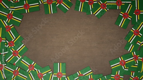 Frame made of paper flags of Dominica arranged on wooden table. National celebration concept. 3D illustration