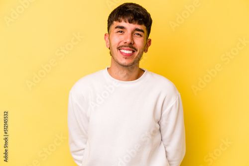 Young caucasian man isolated on yellow background happy, smiling and cheerful.