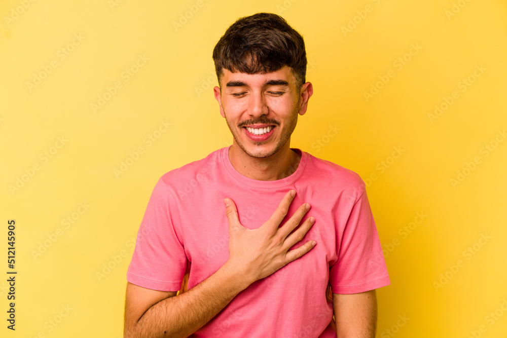 Young caucasian man isolated on yellow background laughs out loudly keeping hand on chest. Young caucasian man isolated on yellow background laughs out loudly keeping hand on chest.