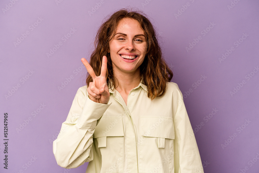 Young caucasian woman isolated on purple background showing number two with fingers. Young caucasian woman isolated on purple background showing number two with fingers.