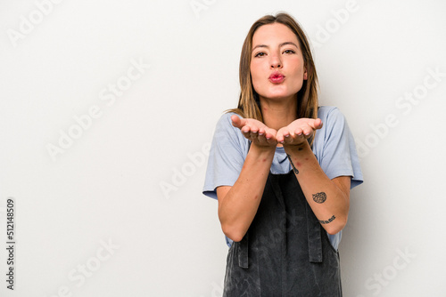 Young caucasian pregnant woman isolated on white background folding lips and holding palms to send air kiss.