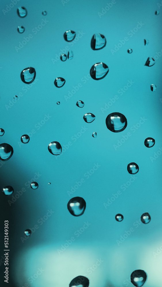 Raindrops on window glass. Abstract turquoise tinted background. Natural mobile phone wallpaper. The rain is over. Macro