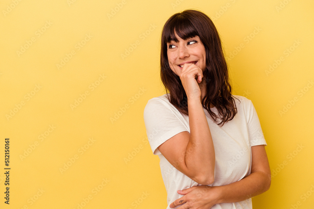 Young caucasian woman isolated on yellow background relaxed thinking about something looking at a copy space. Young caucasian woman isolated on yellow background relaxed thinking about something looking at a copy space.