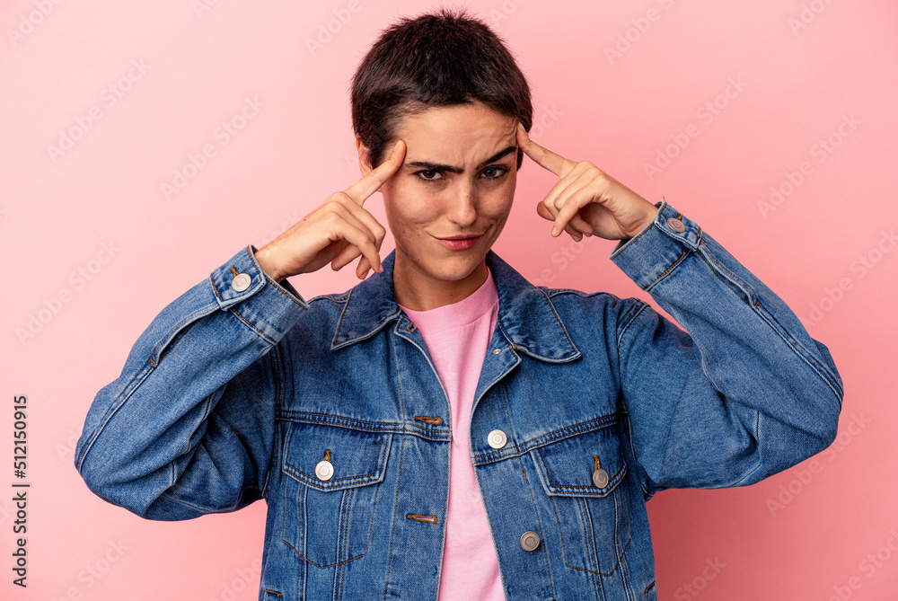 Young caucasian woman isolated on blue background focused on a task, keeping forefingers pointing head. Young caucasian woman isolated on blue background focused on a task, keeping forefingers pointing head.