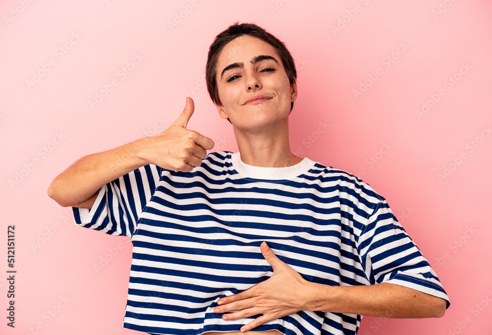 Young caucasian woman isolated on blue background touches tummy, smiles gently, eating and satisfaction concept. Young caucasian woman isolated on blue background touches tummy, smiles gently, eating and satisfaction concept.