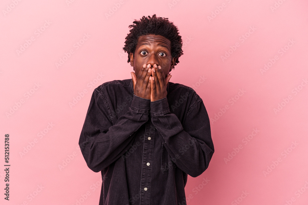 Young african american man isolated on pink background shocked covering mouth with hands. Young african american man isolated on pink background shocked covering mouth with hands.