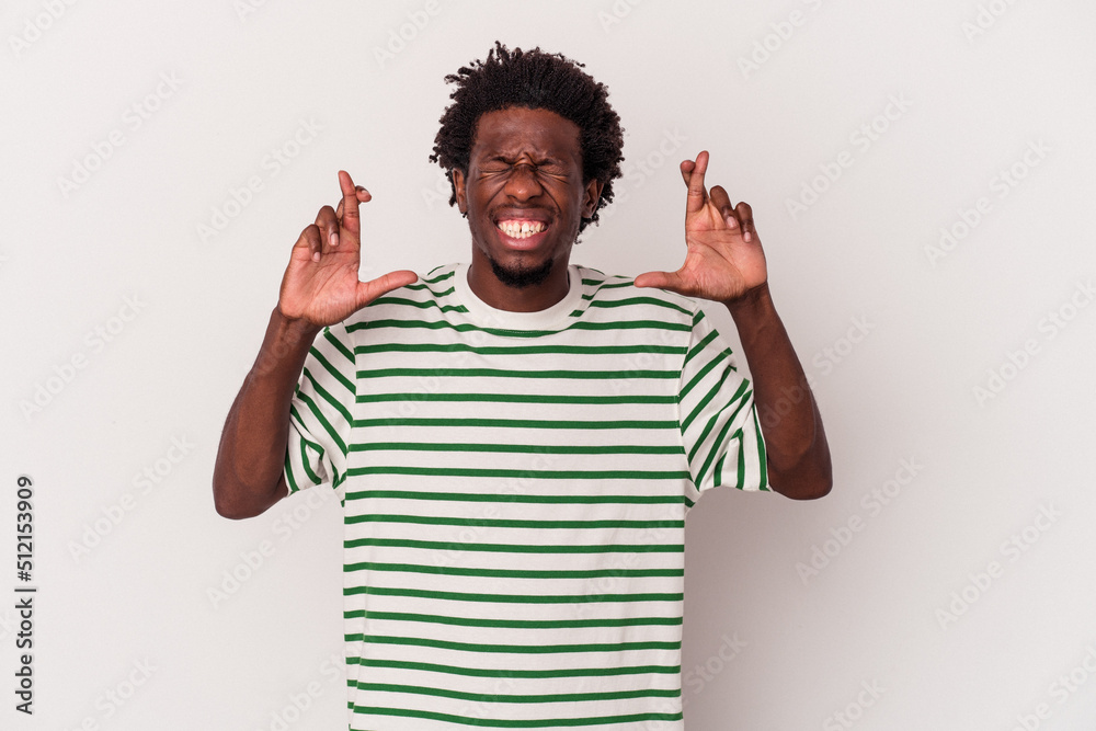 Young african american man isolated on white background crossing fingers for having luck Young african american man isolated on white background crossing fingers for having luck
