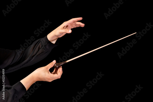 Female conductor conducting a symphony with her baton on a black background