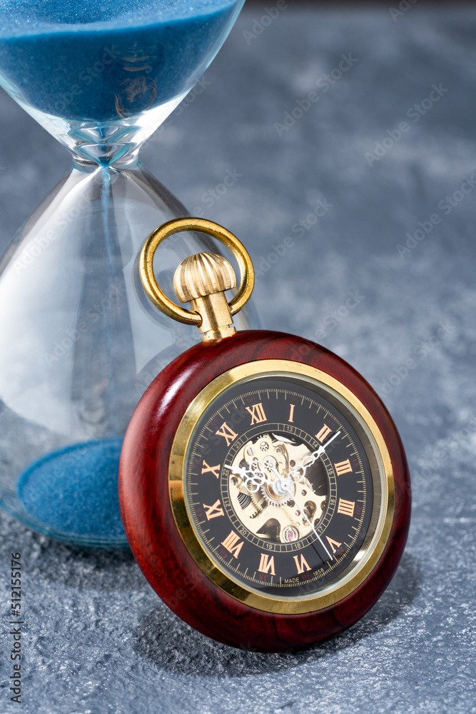 Pocket watch and hourglass on the table Pocket watch and hourglass on the table