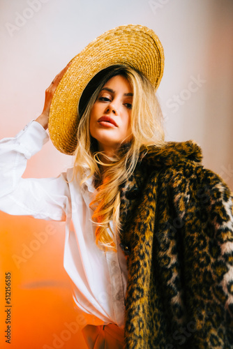 Portrait of attractive caucasian woman in a hat wearing fur coat and stylish outfit.
