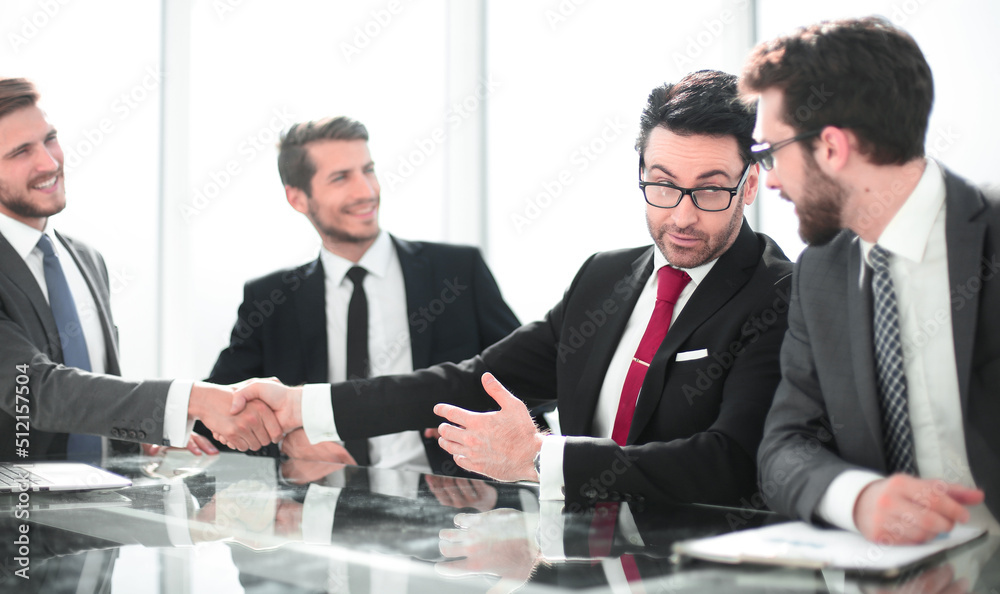handshake of financial partners at a meeting in the office handshake of financial partners at a meeting in the office