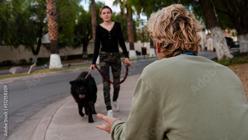 Bilde på lerret Man in a green sweater sees his partner and their dog approaching him