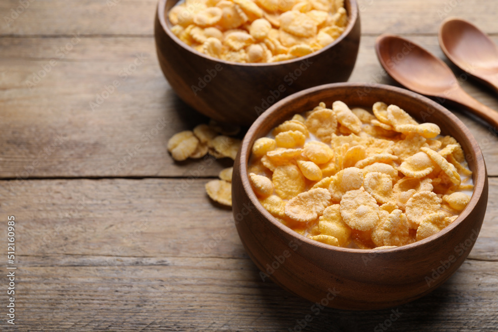 Tasty cornflakes with milk served on wooden table. Space for text Tasty cornflakes with milk served on wooden table. Space for text