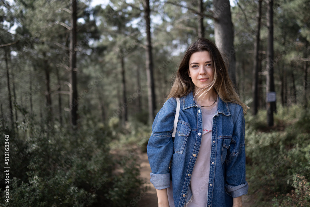 Beautiful young woman in forest. She wears a jean jacket. Beautiful young woman in forest. She wears a jean jacket.