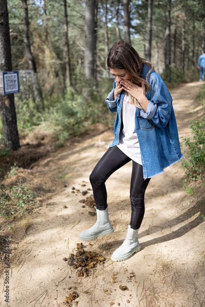 False step. Young woman steps on horse shit. Misadventure and bad accident concept. She is so sad. False step. Young woman steps on horse shit. Misadventure and bad accident concept. She is so sad.