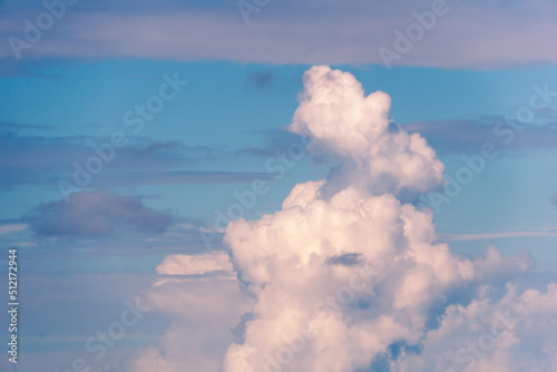 White and blue cloudy background. A large cumulus cloud at sunset. Clouds in the sky.