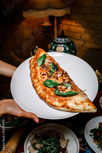 calzone Italian pie, crescent shaped pizza photo