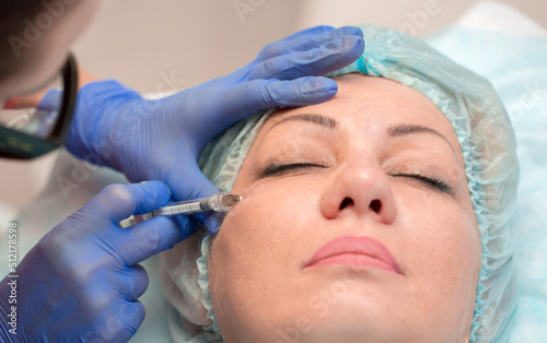 Injection facial rejuvenation. The cosmetologist injects cosmetic injections into the muscles of the face to smooth out wrinkles. Botox and collagen injections at the cosmetologist.